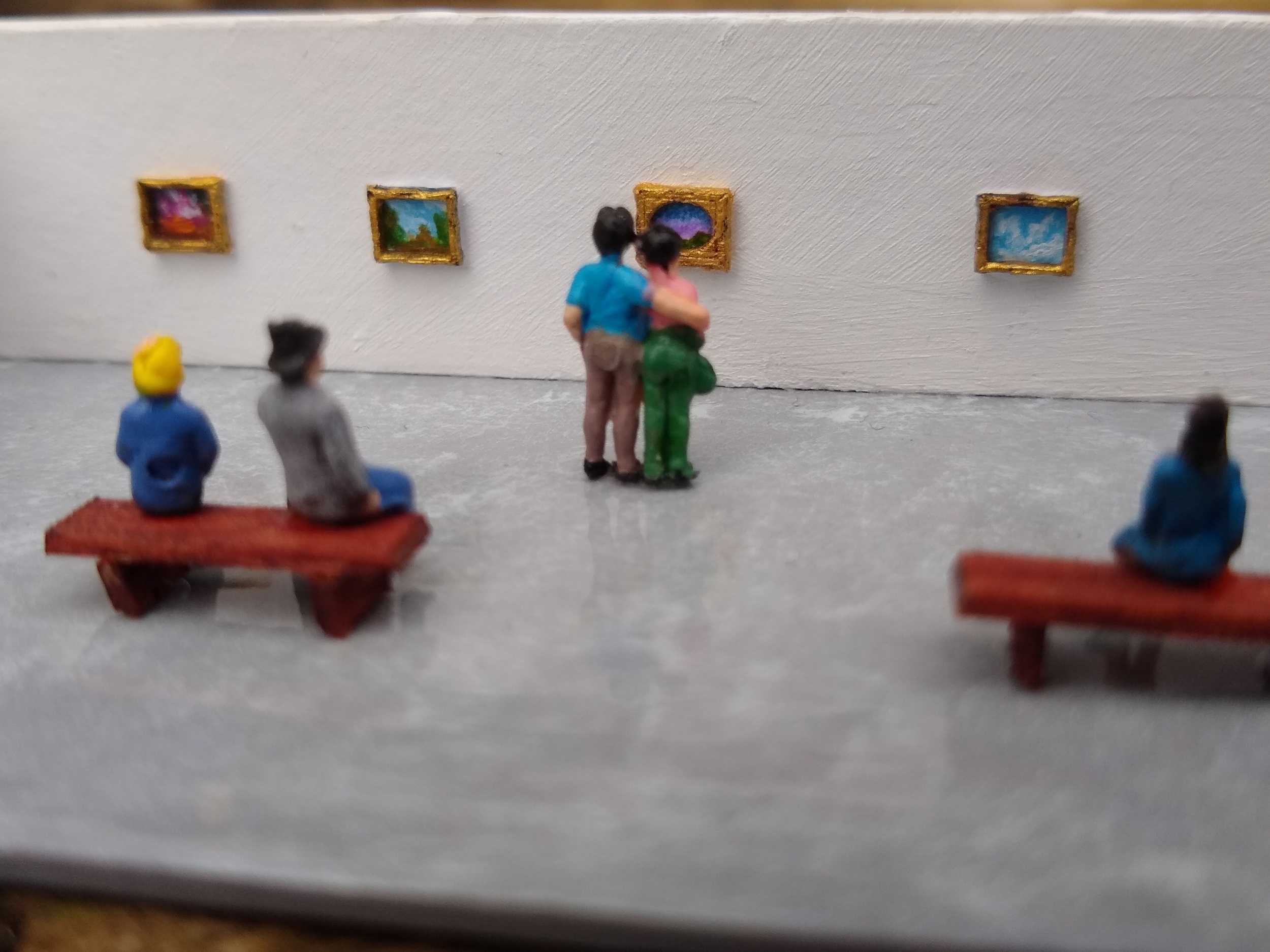 a close up of the artwork on the walls and the people in the art gallery diorama