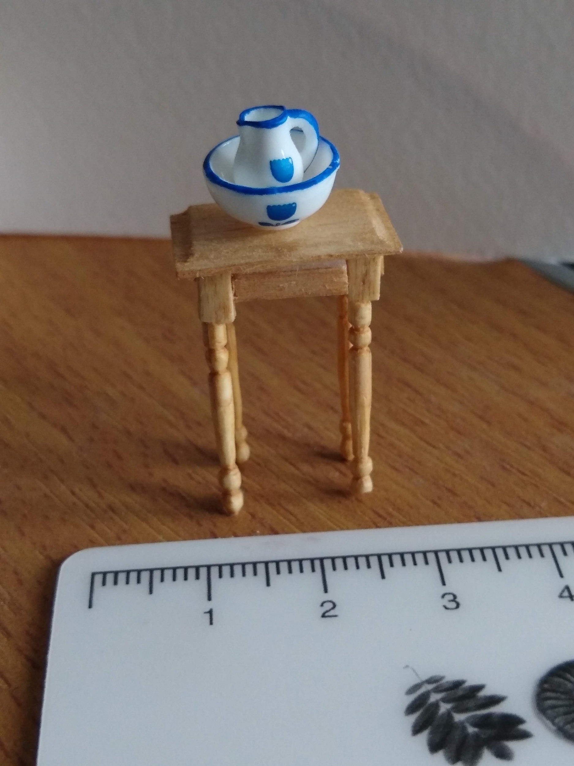 A small wooden table stand for a white and blue chamberpot and bowl, handmade in quarter scale.